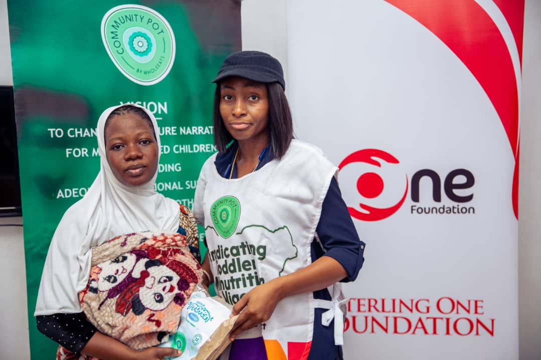 Community Pot Team Lead, Mrs. Kemi Jeje handing over packs of the social impact initiative's organic protein meals to a beneficiary