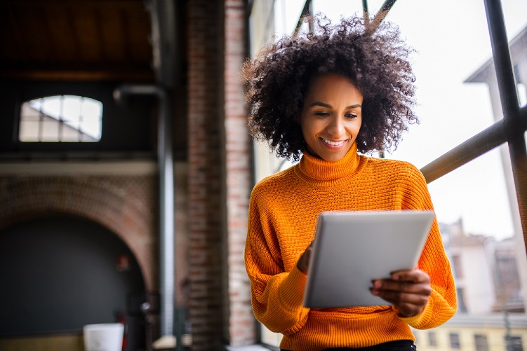 Smiling woman using digital tablet.